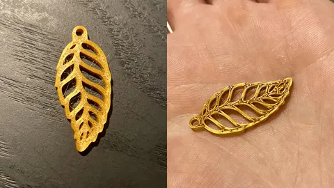 Gold 3D-printed cut-out leaf earring on a dark table and in a hand