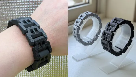 Black 3D-printed chain link bracelet on a wrist, and grey and black bracelets on a stand